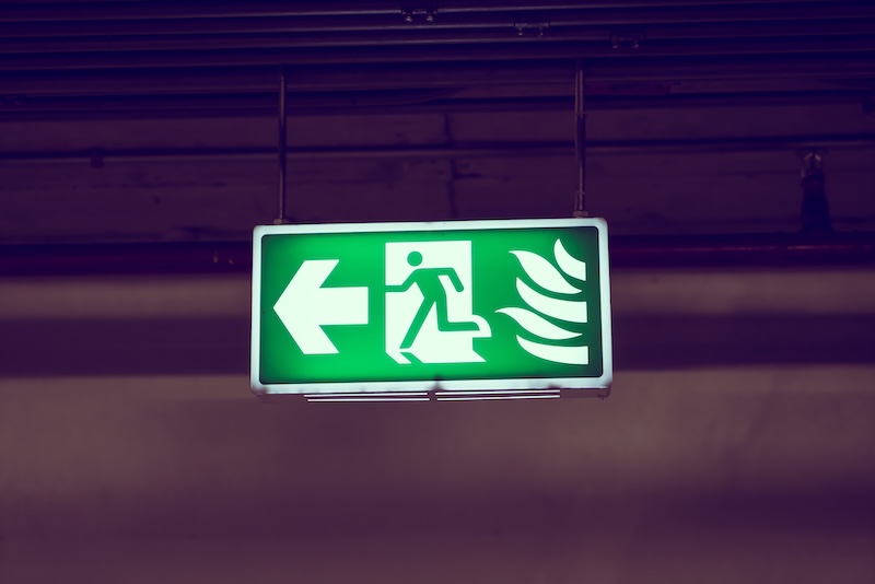 Illuminated emergency light suspended from ceiling