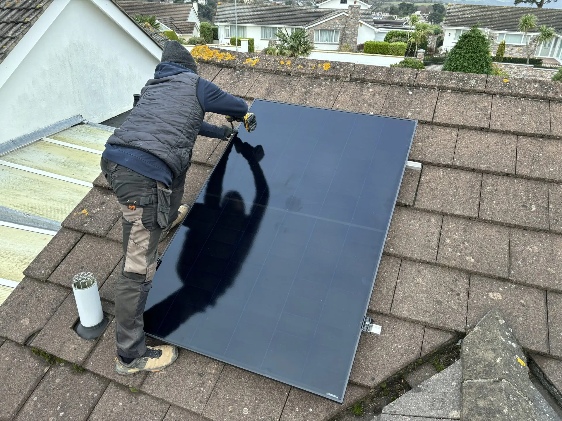 man installing two tier solar panel on roof